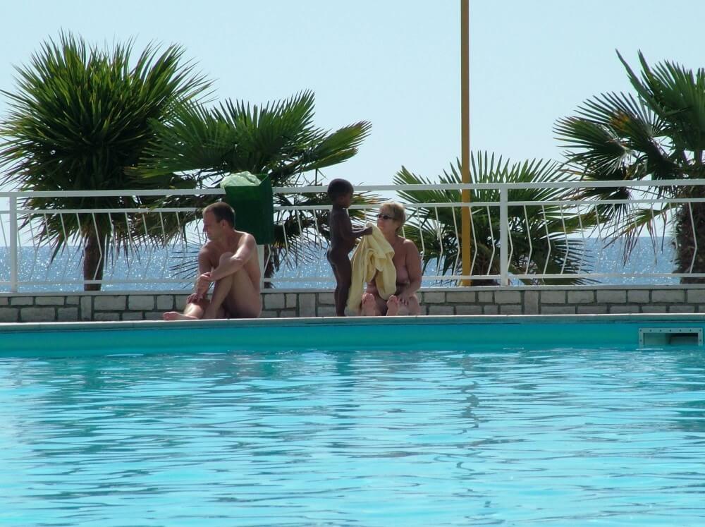 Photo of naturists in an outdoor pool - The practice of nudity within a community